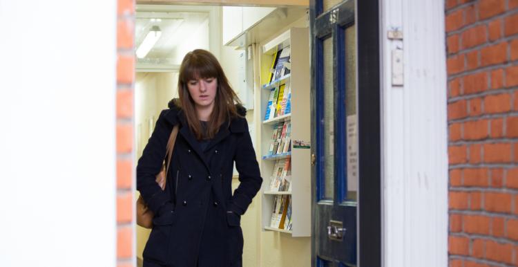 Woman alone walking out of the door looking down