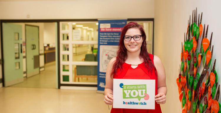 woman holding it starts with you campaign poster in foyer