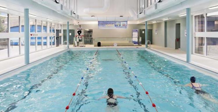 Two people swimming in an indoor pool at Golden Lane