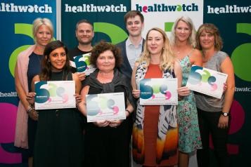 Group of people with certificates at healthwatch event