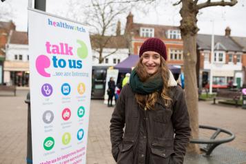 volunteer stood by talk to us banner